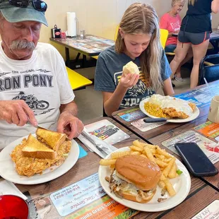 a man and a little girl eating sandwiches