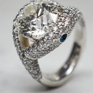 Elliott Shelton's custom diamond engagement ring featuring blue sapphires on either side all pave by hand