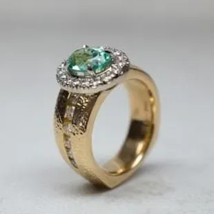 Elliott Shelton's custom ring with a very rare Parabia sapphire with emerald cut diamonds in a hammered rose gold band