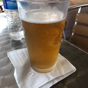 a glass of beer on a napkin