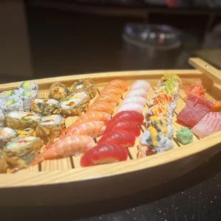 a wooden boat filled with sushi