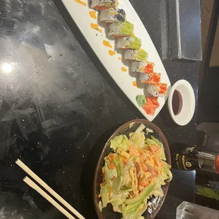 a plate of sushi and a bowl of salad