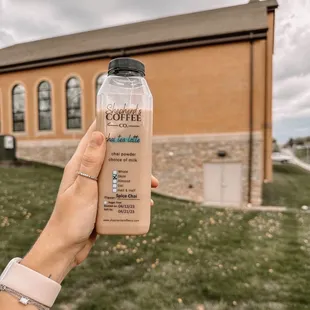 a person holding a bottle of coffee