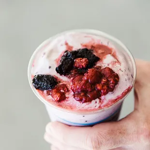 a hand holding a cup of frozen custard