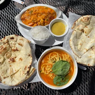 Thukpa noodles at the bottom, korma on the top, garlic naan on the left, regular naan on the right