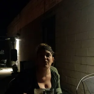 a woman sitting at a table with food and drinks