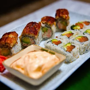 a plate of sushi with dipping sauce