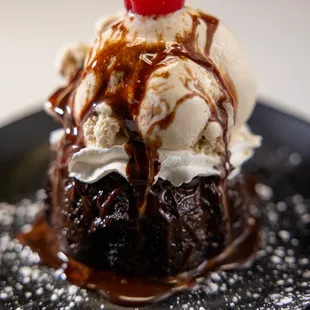 a chocolate cake with ice cream and a cherry on top