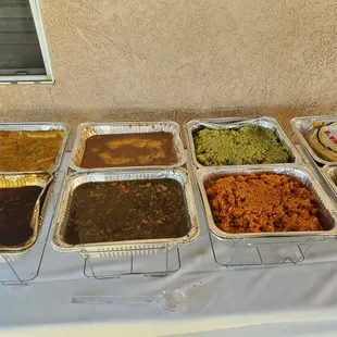 Chicken enchiladas and chile colorado, refried beans, borracho beans, Spanish rice, and poblano rice. Salsa and guacamole were included also