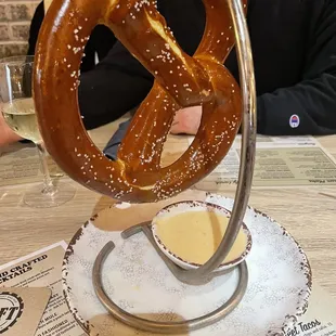 a pretzel being dipped with salt