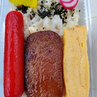 $3.99 bento includes hotdog, spam, tamagoyaki, fishcake, furikake, and takuan on a bed of white rice