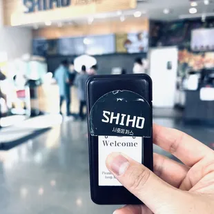 a hand holding a phone with a sticker on it