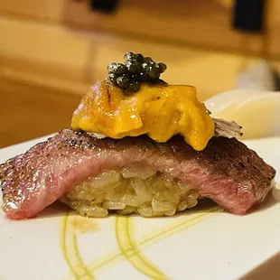 a piece of steak with cauliflower on top