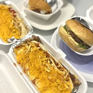 a tray of hotdogs and a tray of cheeseburger