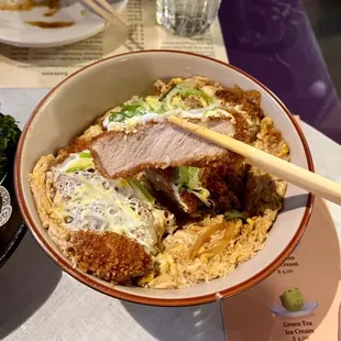 a bowl of food with chopsticks