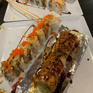 two plates of sushi with chopsticks