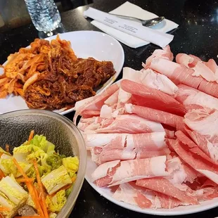 Large plate is beef brisket, other plate is spicy bulgogi and spicy pork belly,  sides and salad