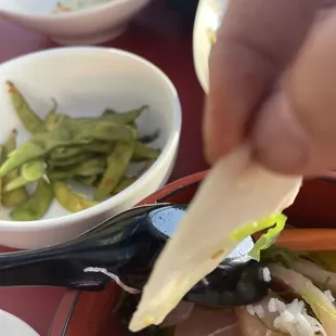 a person dipping a piece of food into a bowl