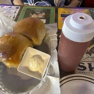 Dinner rolls with butter and a squeeze bottle of a jelly I couldn't identify.