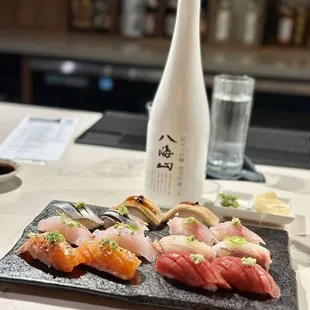 a variety of sushi on a slate plate