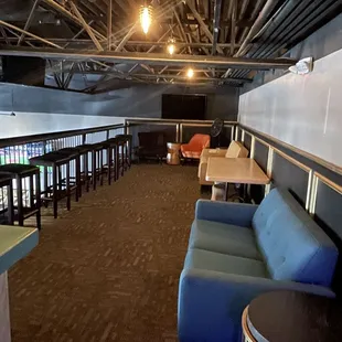 an empty bar with blue couches