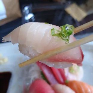 a plate of sushi with chopsticks