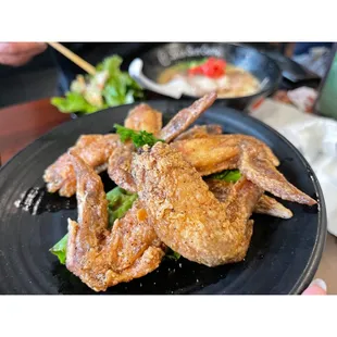 ows a black plate with fried chicken legs on it