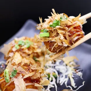 a hand holding a pair of chopsticks