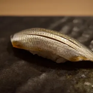 a piece of fish on a black plate