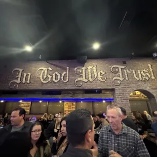 In God We trust painted on brick