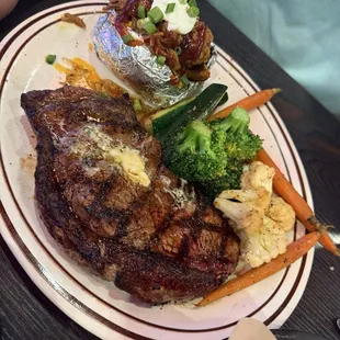 New York steak, loaded baked potato and steamed vegetables