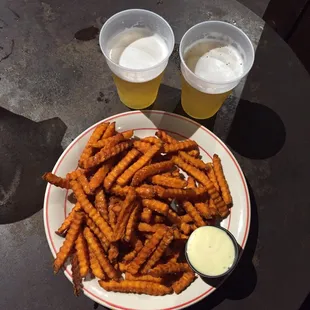 a plate of fries and two cups of beer