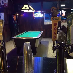 a pool table and neon signs