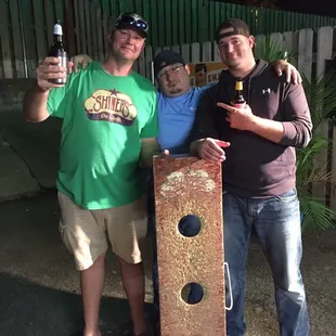 three men holding beer bottles