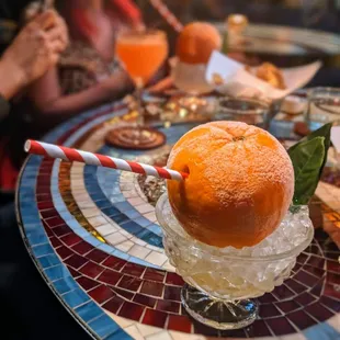 a glass of orange juice with a straw