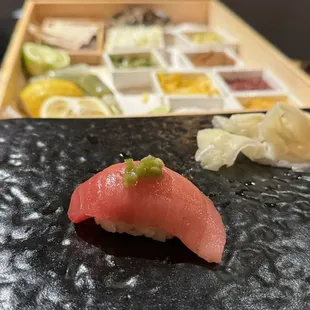 a sushi dish on a black plate