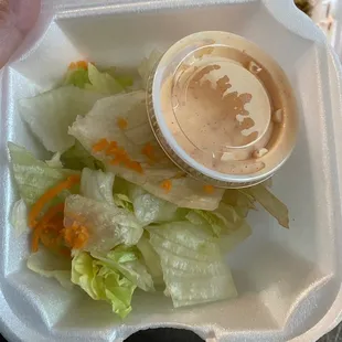 a salad in a styrofoam container