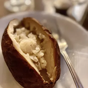 a baked potato on a plate with a fork