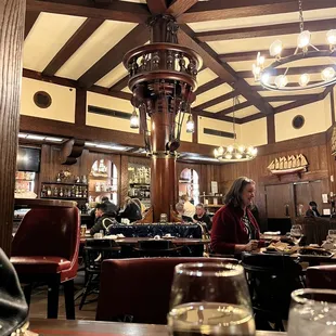 a woman sitting at a table with a glass of wine