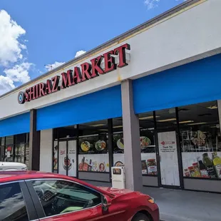 a red car parked in front of the store