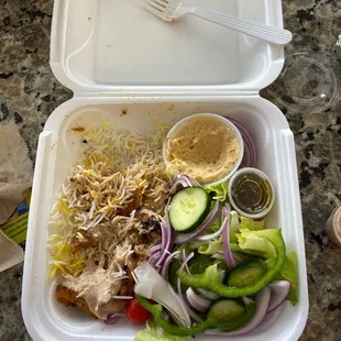 a plastic container with a salad and a fork
