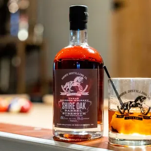 a glass of whiskey next to a bottle