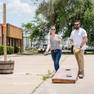a man and a woman playing corn hole