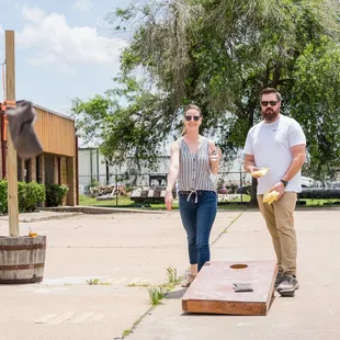 a man and a woman playing corn hole