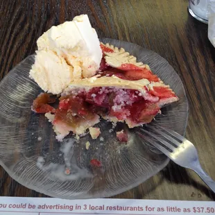 1/2 eaten Strawberry Rhubarb pie a la mode