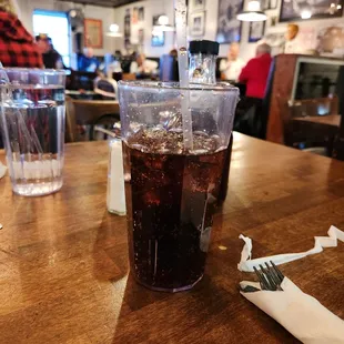 a plastic cup of soda on a table