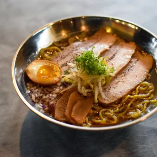 a bowl of ramen with meat and vegetables