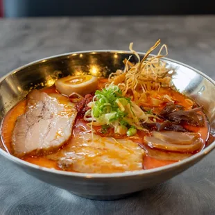a bowl of ramen with meat and vegetables