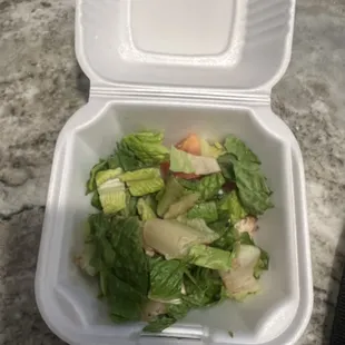 a salad in a styrofoam container