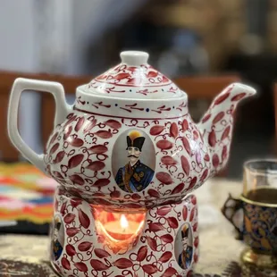 a teapot with a lit candle
